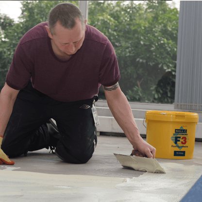 F-Ball Styccobond F3 adhesive being trowelled onto a subfloor