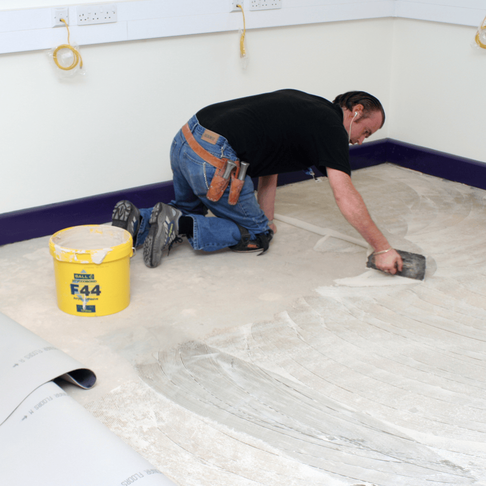 Styccobond F44 vinyl adhesive being trowelled onto a subfloor