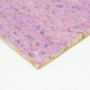 A close-up of a corner of a purple and pink speckled particle board against a white background.